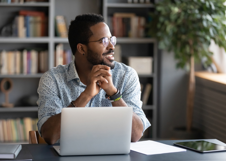 Man smiling in front of a laptop